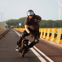 Hombre montando el monociclo eléctrico InMotion V12S por la carretera