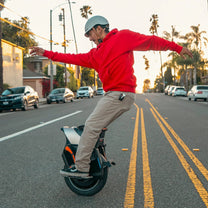 Hombre montando el monociclo eléctrico InMotion V12S por la carretera