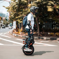 Hombre montando el monociclo eléctrico InMotion V14 Adventure por la ciudad