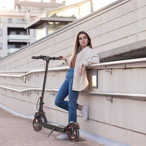 Mujer de pie junto al patinete eléctrico iScooter i9 Max
