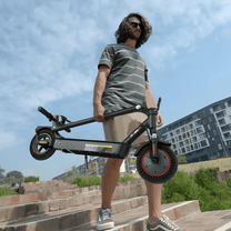 Persona de pie junto al patinete eléctrico iScooter i9 Max