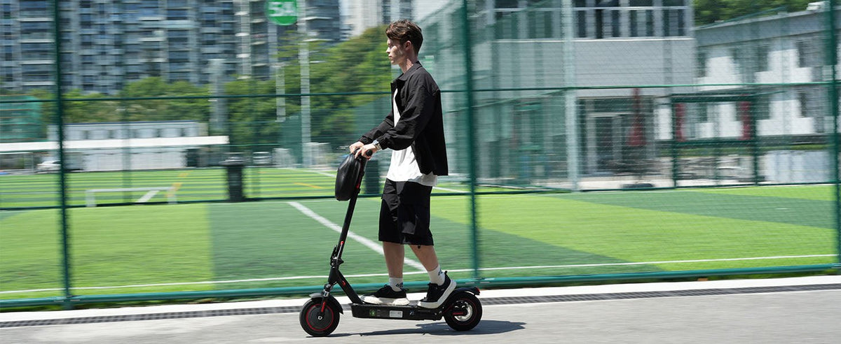 Persona circulando con el patinete eléctrico iScooter i9 Max por la ciudad