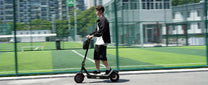 Persona circulando con el patinete eléctrico iScooter i9 Max por la ciudad