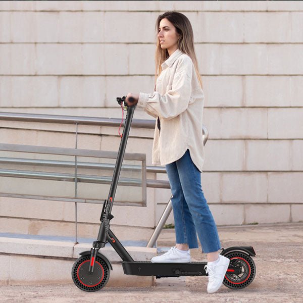 Mujer de pie junto al patinete eléctrico iScooter i9 Max