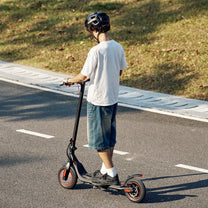 Persona de pie junto al patinete eléctrico iScooter i9M