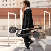 Persona llevando el patinete eléctrico iScooter iX3 plegado