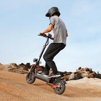 Piloto con el patinete eléctrico iScooter iX8 fuera de pista sobre terreno arenoso