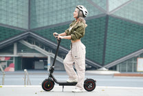 Mujer montando el patinete eléctrico iScooter W6 por la ciudad