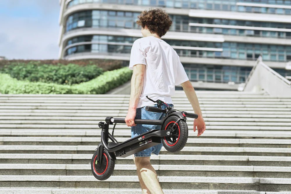 Persona llevando el patinete eléctrico iScooter W6 plegado