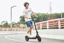 Persona circulando con el patinete eléctrico iScooter W6 por la ciudad