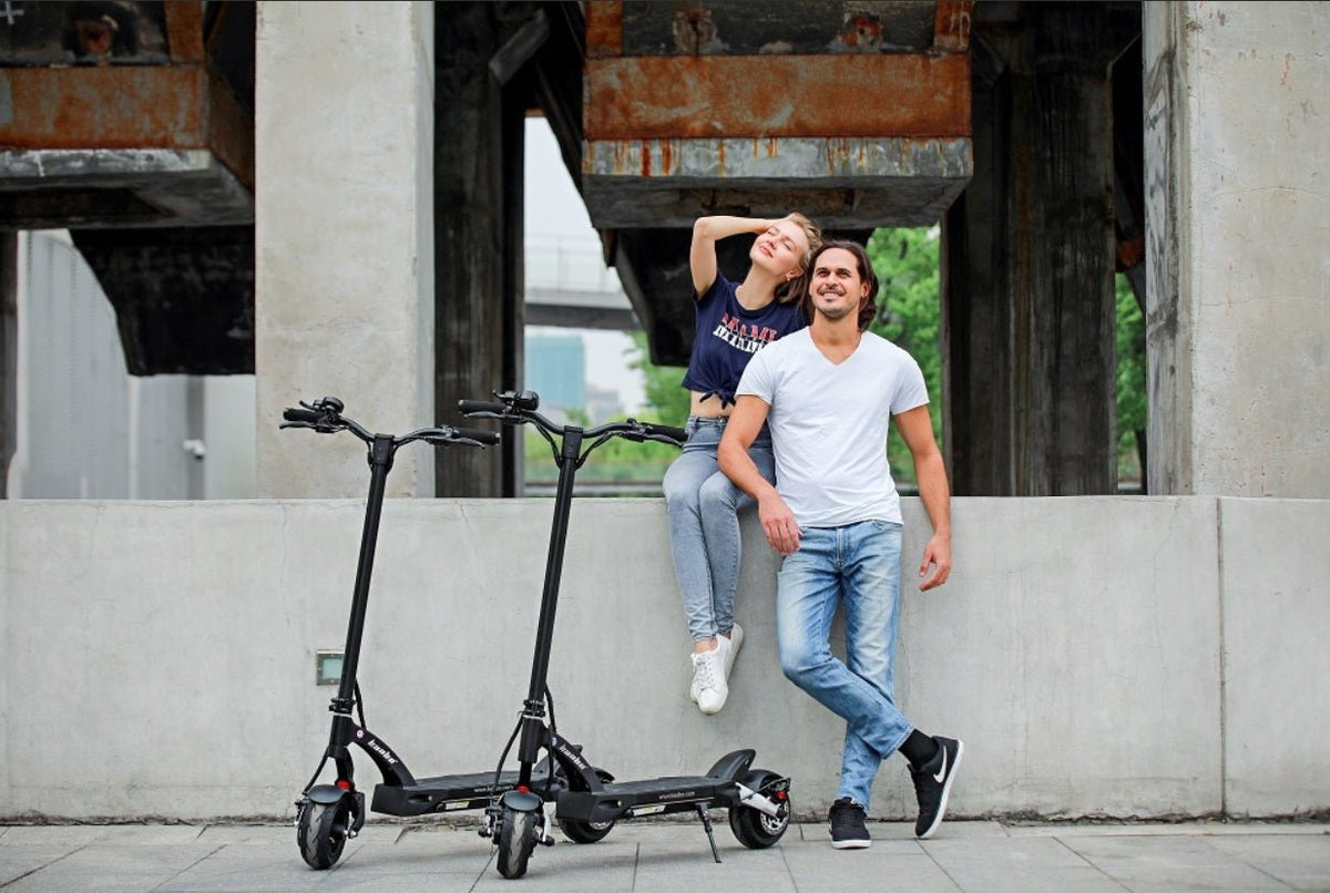 Dos personas con el patinete eléctrico KAABO MANTIS 8 PLUS por una calle