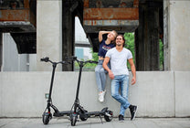 Dos personas con el patinete eléctrico KAABO MANTIS 8 PLUS por una calle