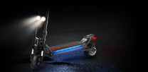 Patinete eléctrico KAABO WOLF WARRIOR X MAX con las luces encendidas sobre fondo oscuro