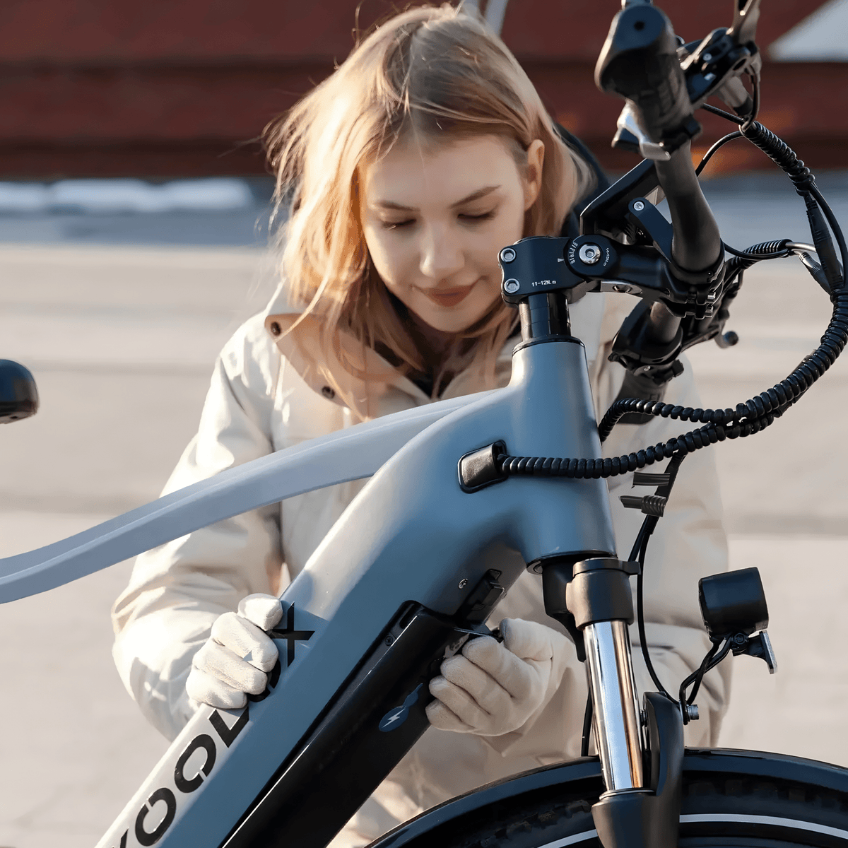 Mujer de pie junto a la bicicleta eléctrica KOOLUX X3 en la ciudad