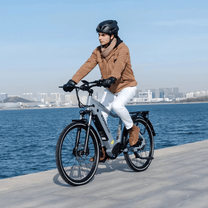 Hombre montando la bicicleta eléctrica KOOLUX X3 junto al mar