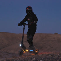 Persona de pie junto al patinete eléctrico KuKirin G2 Master en un ambiente nocturno