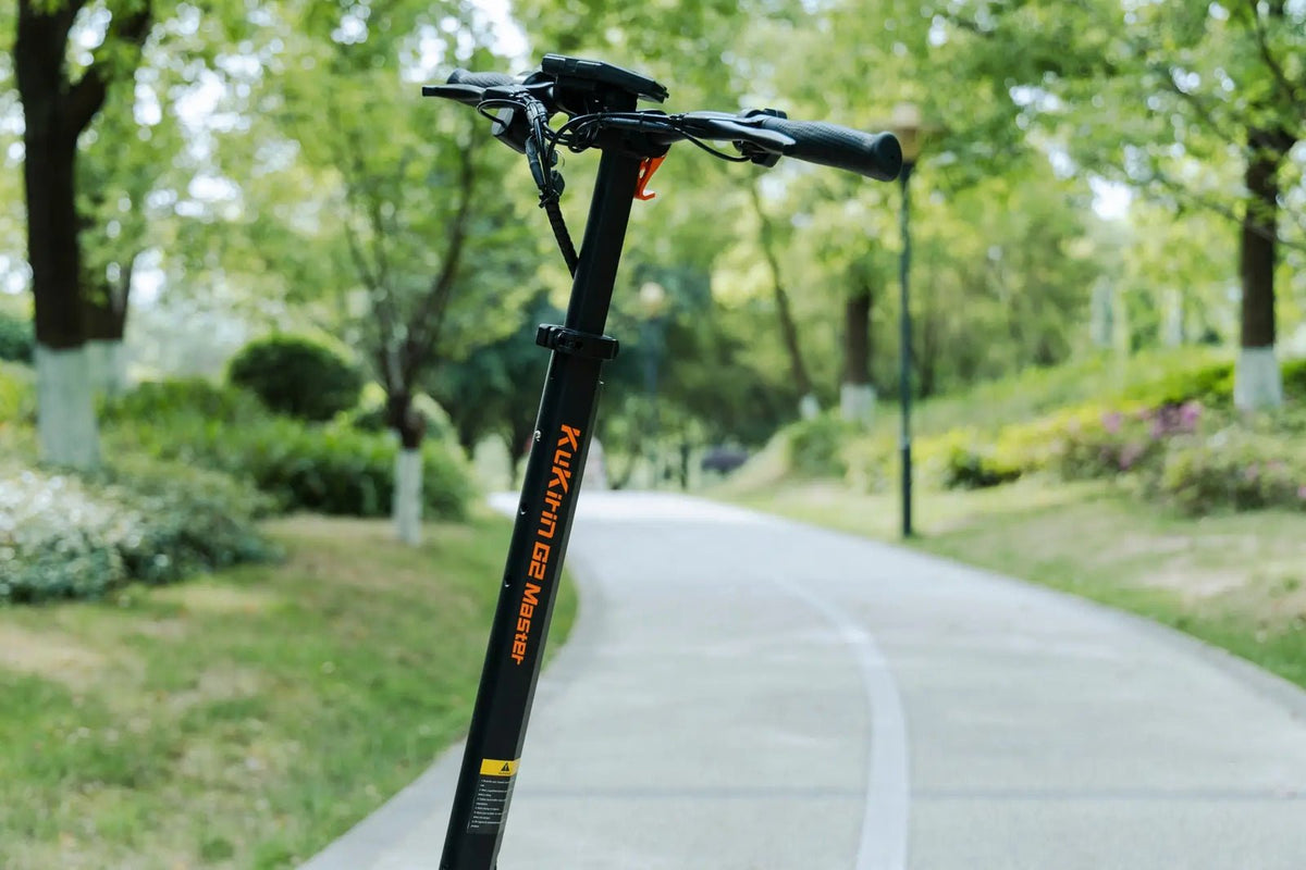 Patinete eléctrico KuKirin G2 Master visto de lado en un camino peatonal