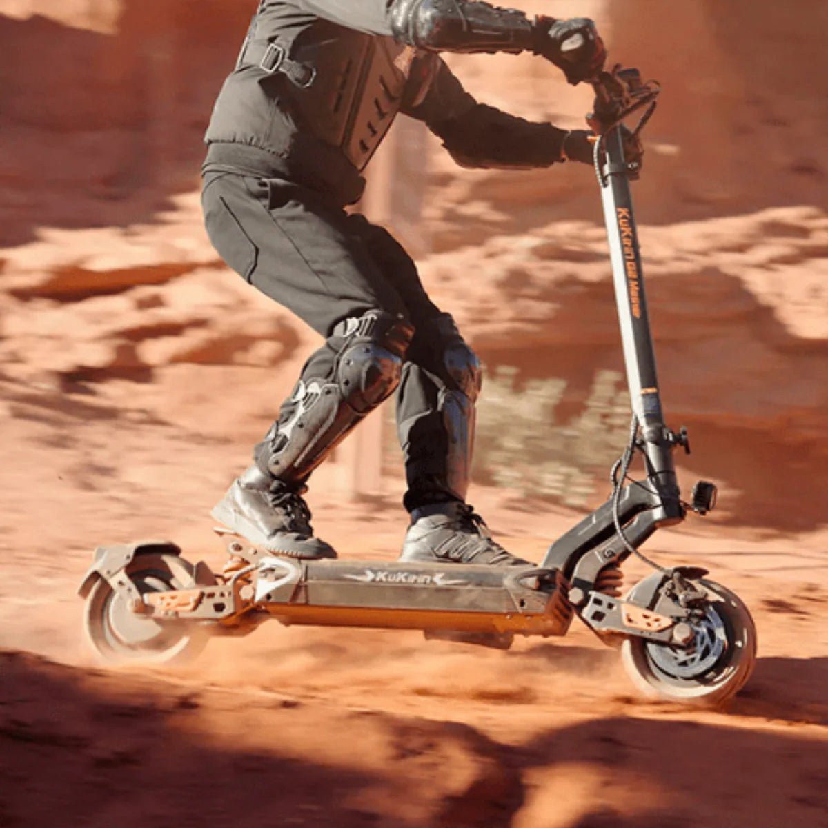 Piloto con el patinete eléctrico KuKirin G2 Master fuera de pista sobre terreno arenoso