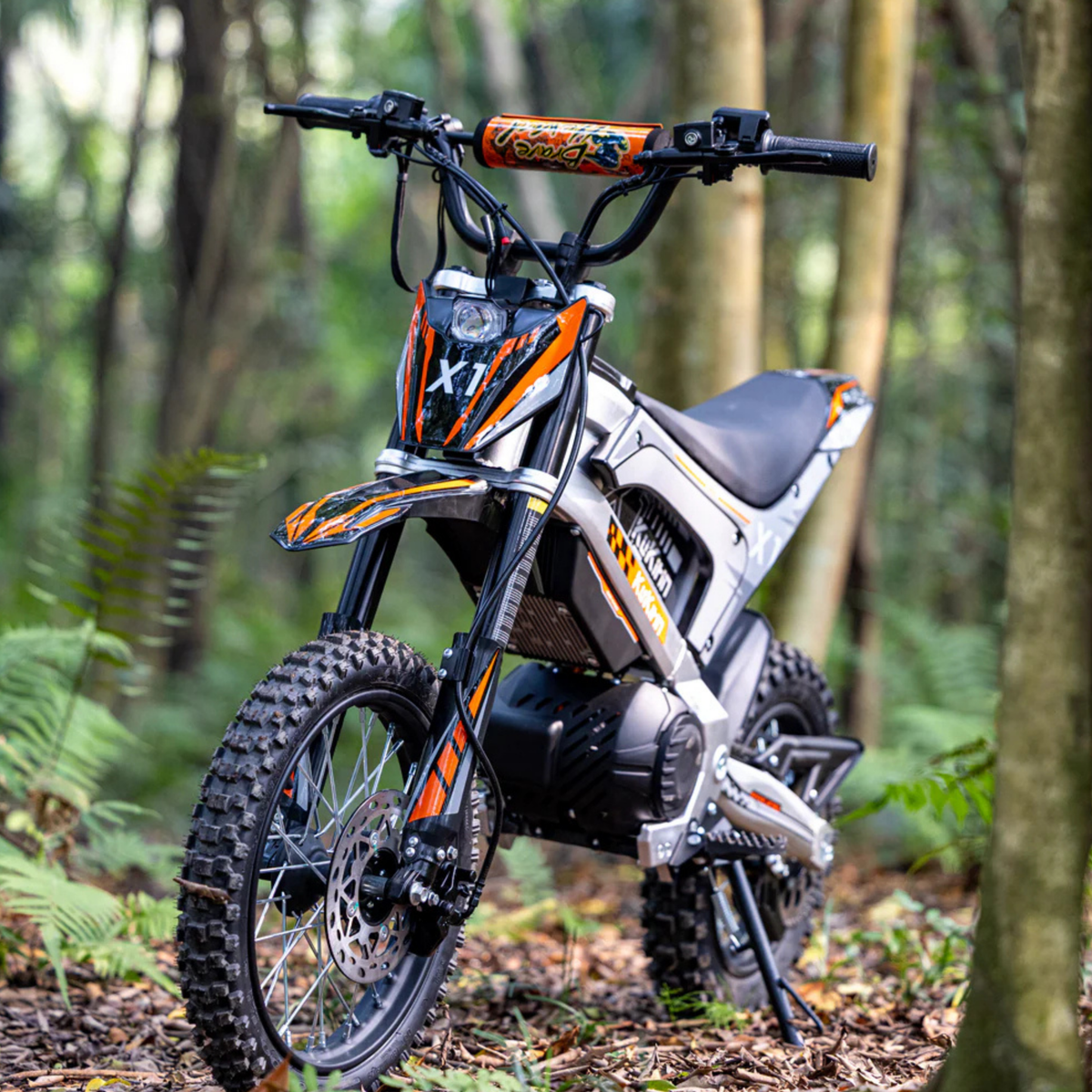 Persona de pie junto a la moto cross eléctrica KuKirin X1 en el bosque