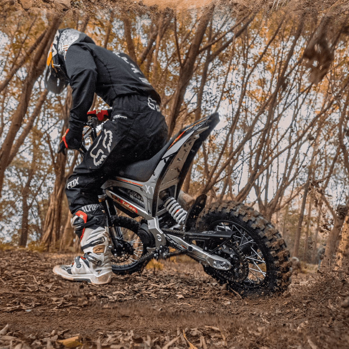 Piloto con la moto cross eléctrica KuKirin X1 fuera de pista en el bosque