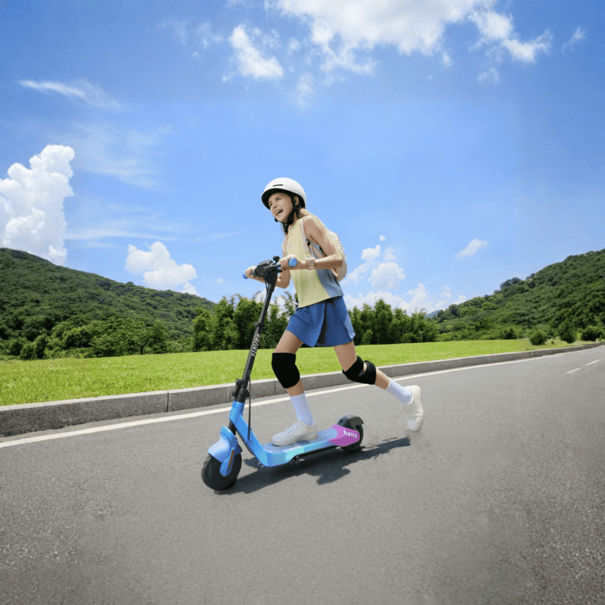 Persona de pie junto al patinete eléctrico infantil NAVEE K100 Max con un niño