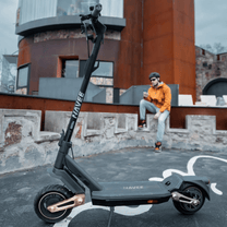 Persona de pie junto al patinete eléctrico NAVEE ST3 Pro por una calle