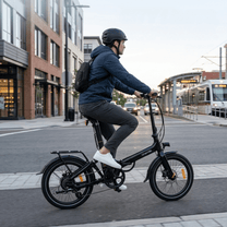 Hombre montando la bicicleta eléctrica plegable Onemile E2 por la carretera