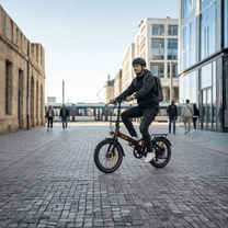 Hombre montando la bicicleta eléctrica plegable Onemile E2 por una calle
