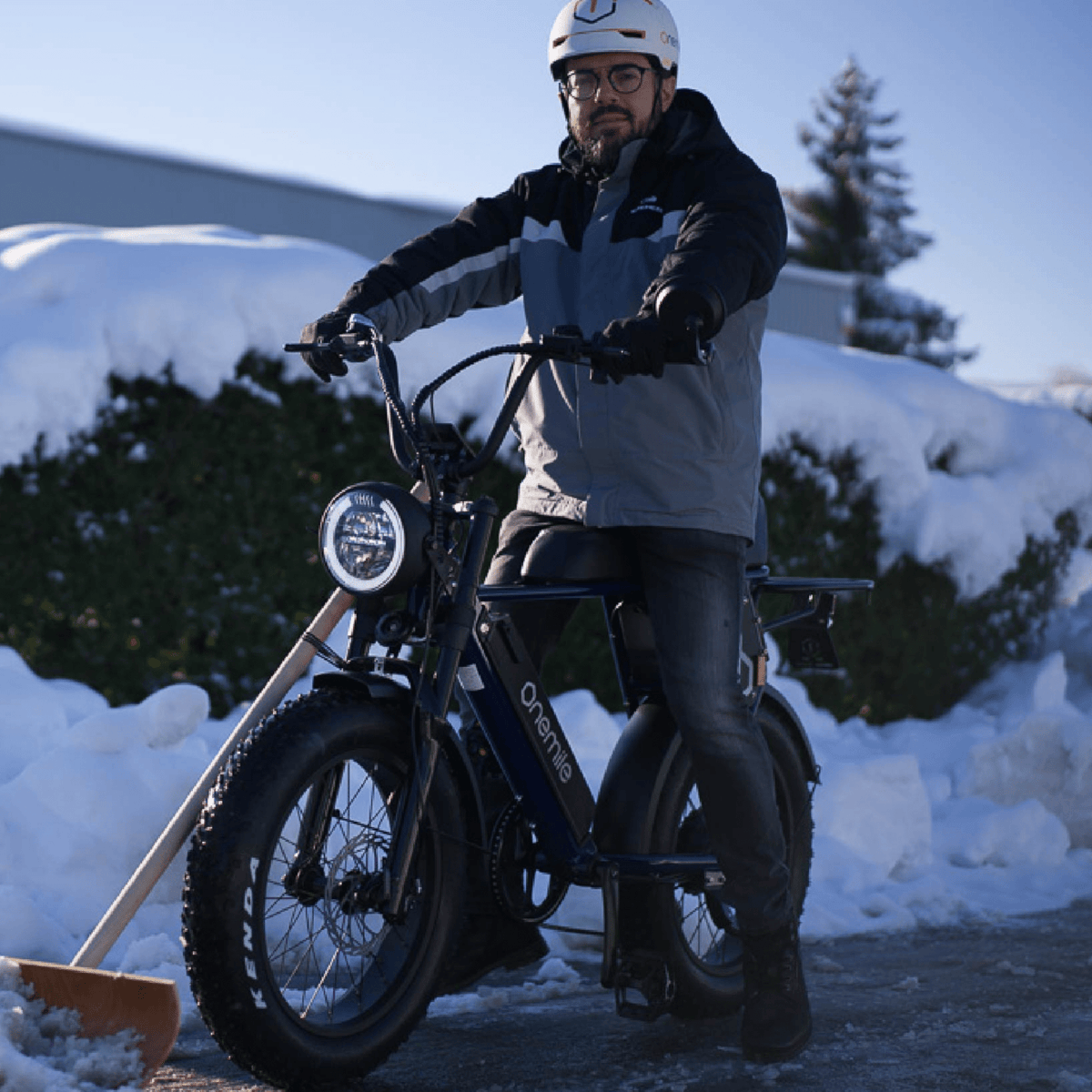 Hombre de pie junto a la bicicleta eléctrica fat bike Onemile P40 Pro en la nieve