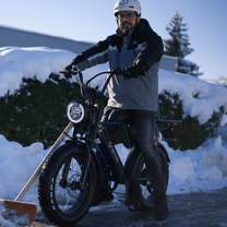 Hombre de pie junto a la bicicleta eléctrica fat bike Onemile P40 Pro en la nieve