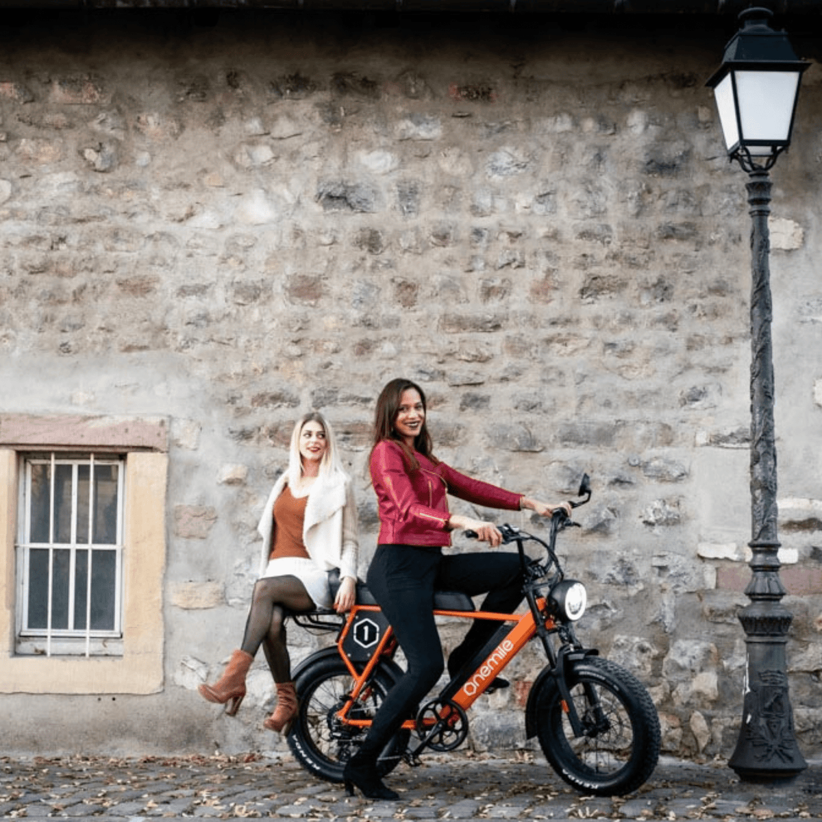 Dos personas con la bicicleta eléctrica fat bike Onemile P40 Pro por una calle