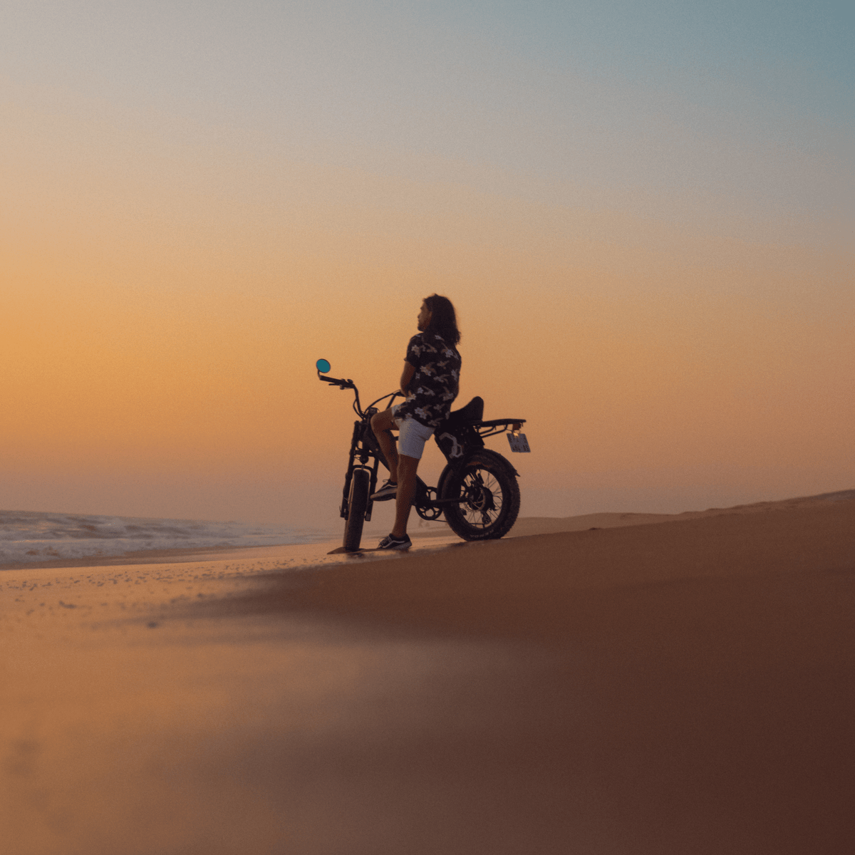 Persona montando la bicicleta eléctrica fat bike Onemile P40 Pro al atardecer