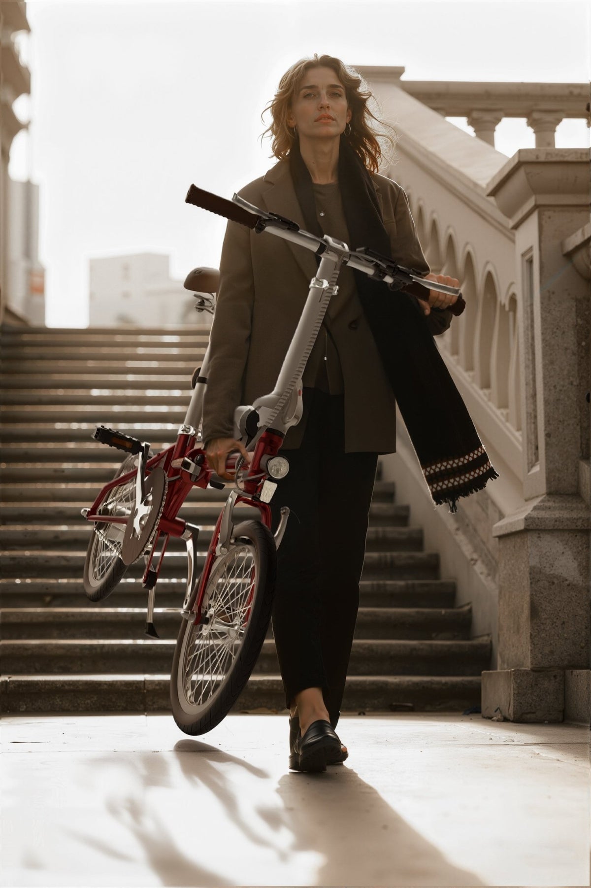 Mujer de pie junto a la bicicleta eléctrica plegable OneSport OT02 en interior