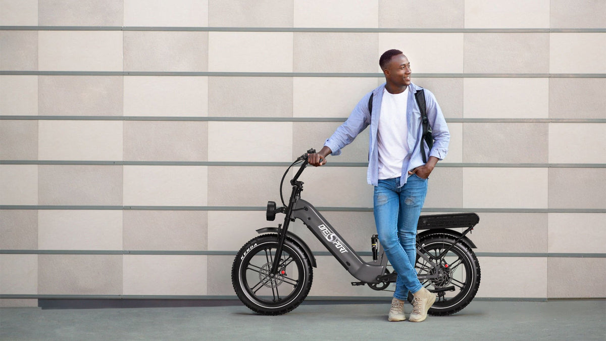 Hombre de pie junto a la bicicleta eléctrica fat bike OneSport OT08 Pro en color gris por una calle