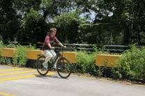 Persona montando la bicicleta eléctrica OneSport OT12 en color negro en un parque