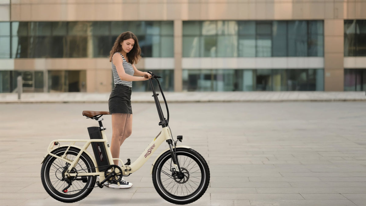 Mujer de pie junto a la bicicleta eléctrica plegable OneSport OT16-2 en color beige en la ciudad