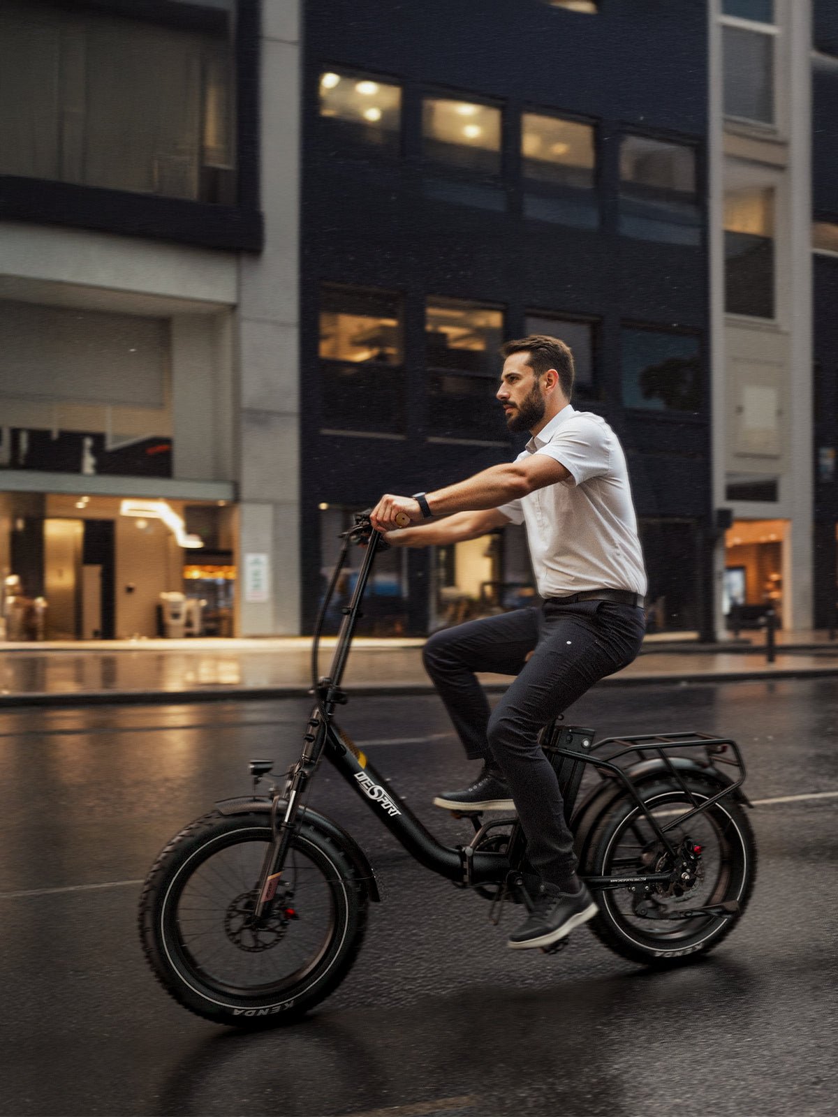 Hombre montando la bicicleta eléctrica plegable fat bike OneSport OT16 Max en color negro en un ambiente nocturno