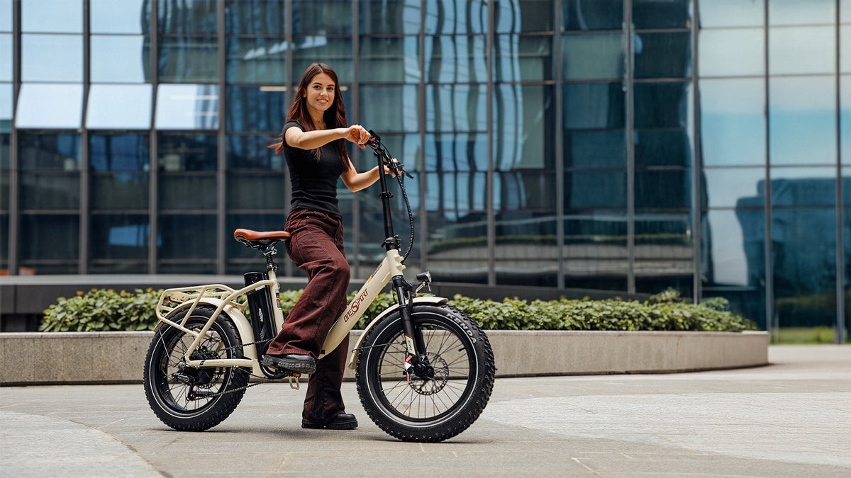 Mujer de pie junto a la bicicleta eléctrica plegable fat bike OneSport OT16 Max en color beige en la ciudad