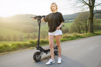 Mujer de pie junto al patinete eléctrico OOTD T10