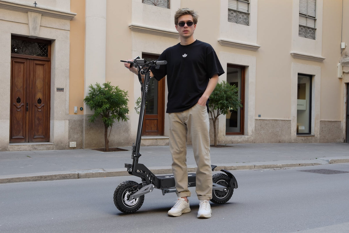 Hombre de pie junto al patinete eléctrico OOTD T10 en la ciudad