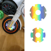 Pegatina reflectante de seguridad para cubierta de rueda en acabado holográfico en el patinete eléctrico en primer plano