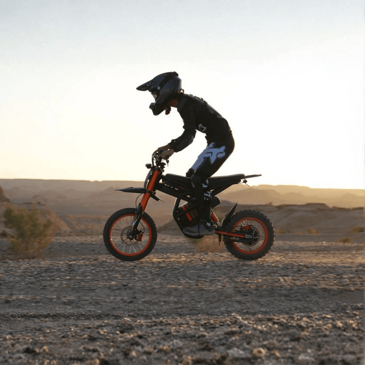 Piloto saltando con la moto cross eléctrica Ridingtimes GT54 al atardecer