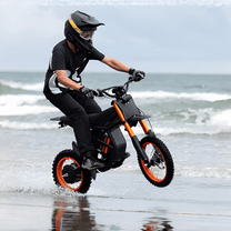Piloto con la moto cross eléctrica Ridingtimes GT54 fuera de pista junto al mar