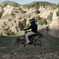 Piloto con la moto cross eléctrica Ridingtimes GT54 fuera de pista en la montaña