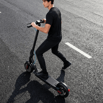 Hombre montando el patinete eléctrico SEEDREAM RED WING MINI por la carretera