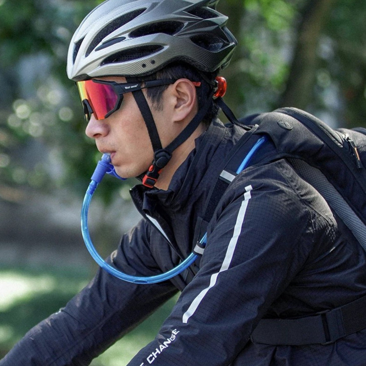 Ciclista bebiendo del tubo: mochila inteligente con bolsa de hidratación