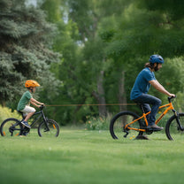 Cuerda de remolque retráctil inteligente con gancho para bicicleta remolcando una bicicleta infantil