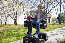 Hombre sentado en el scooter de movilidad Sweetrich S1 Sport en un parque