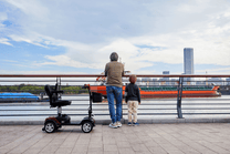Hombre de pie junto al scooter de movilidad Sweetrich S1 Sport