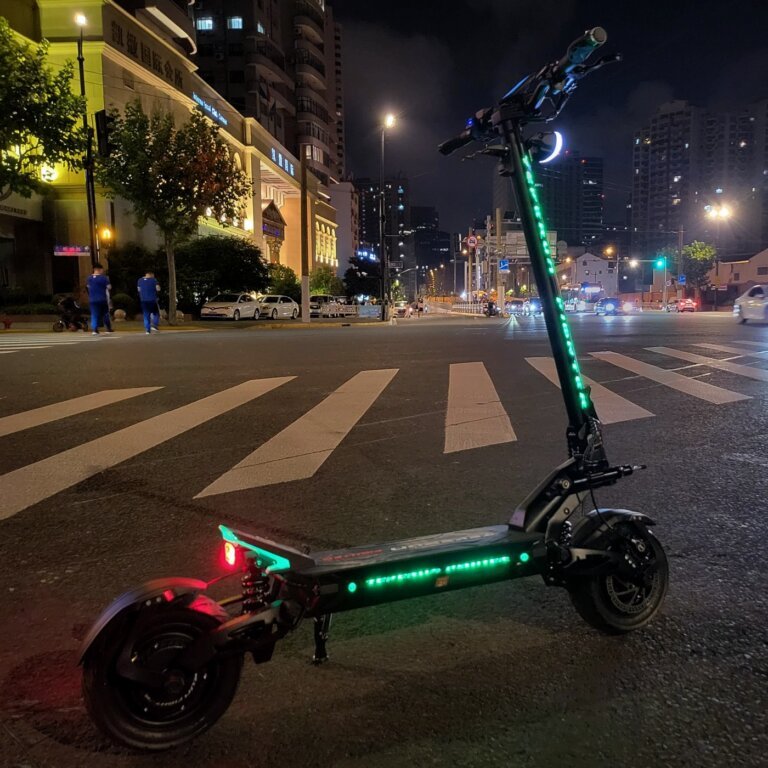 Patinete eléctrico TEVERUN FIGHTER ELEVEN+ V4 con las luces encendidas en un ambiente nocturno